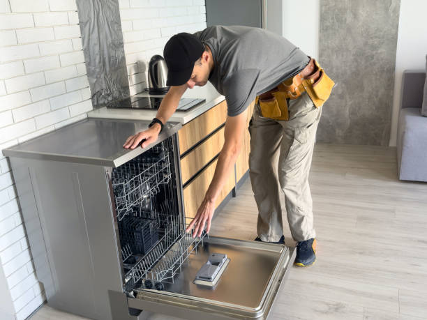 Young repairman service worker repairing dishwasher appliance in the kitchen for appliance installation services in Miami, FL.