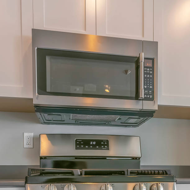 A stainless steel stove and oven with an over-the-range microwave in a modern kitchen setting.