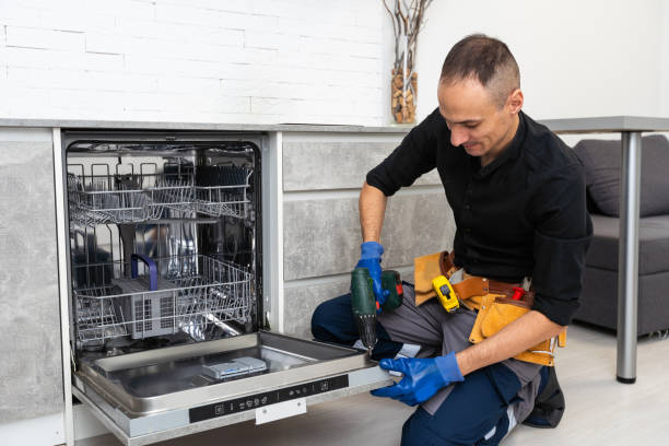 A man is engaged in repairing a dishwasher in the kitchen, highlighting the installation task.