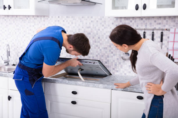 A man and woman collaborating on a kitchen counter, focused on cooktop installation services.