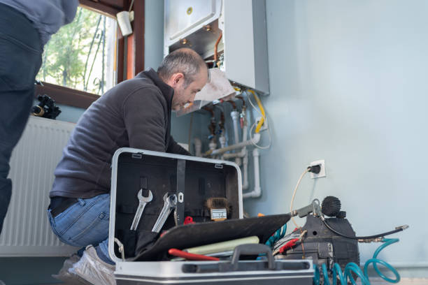 A man and woman focused on installing a gas boiler, demonstrating teamwork in a home improvement project.