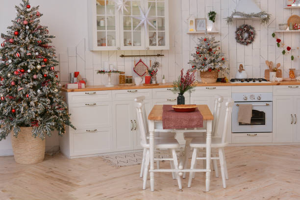 A cozy kitchen featuring a table and chairs, with a decorated Christmas tree in the background.

