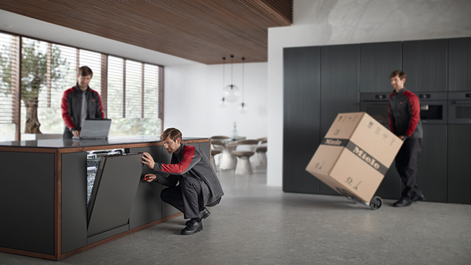 Professional appliance installation crew members are working in a house and isntalling equioment