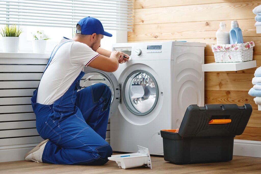 Technician installing a washing machine in a laundry room